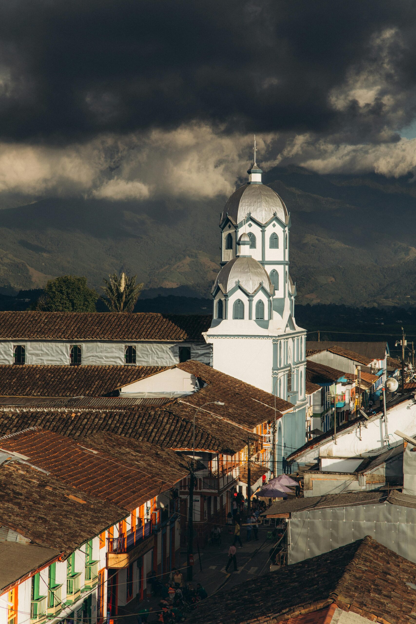 Filandia's iconic Iglesia Maria Inmaculada stands tall against a backdrop of dramatic storm clouds, showcasing the town's charm.